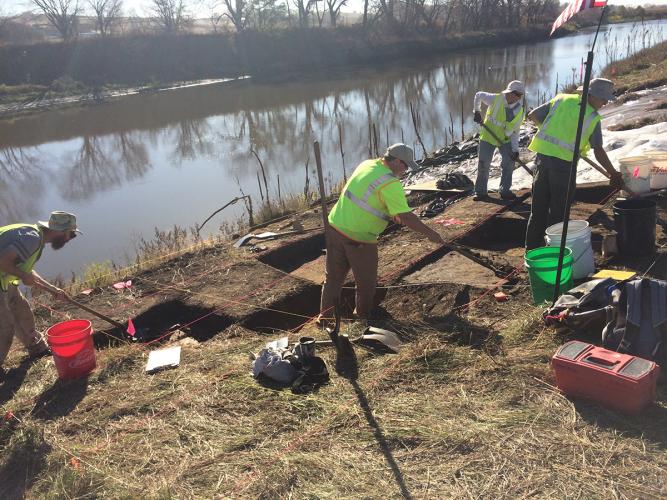 Crew members work along a riverbed.