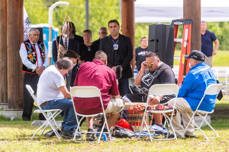 Drummers sit in a circle and play.