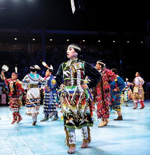 A dancer wearing a jingle dress