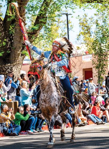 Parade Co_Marshall Shane Red Hawk, dressed in regalia, riding a horse 