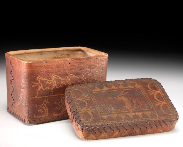 A brown birchbark box and its lid, decorated with engravings