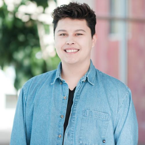 Portrait of a young man wearing a blue collared shirt