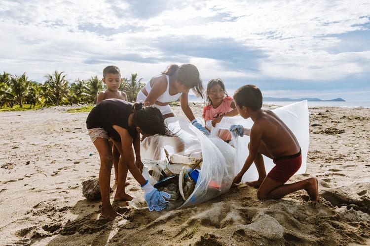 Young people gather trash on the beach