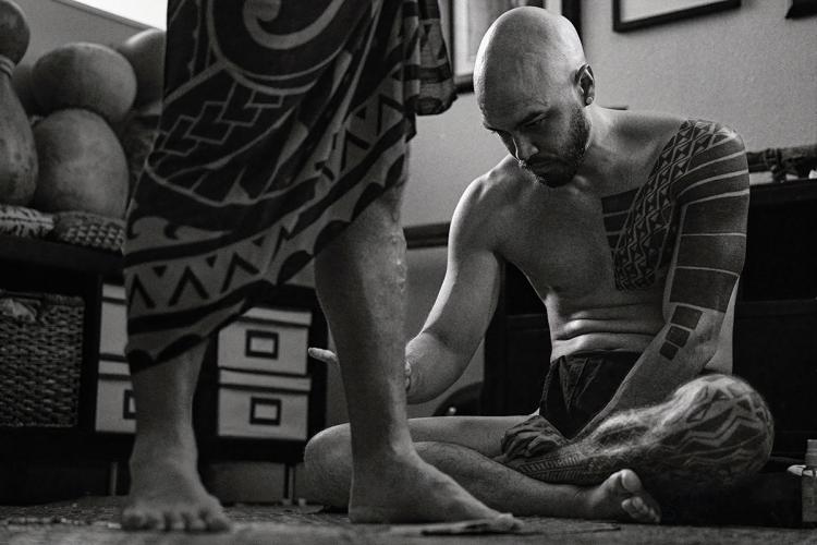 A traditional tattoo artist at work