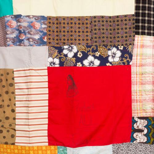 A closeup of a quilt piece with text, including the words "Protect All People" 