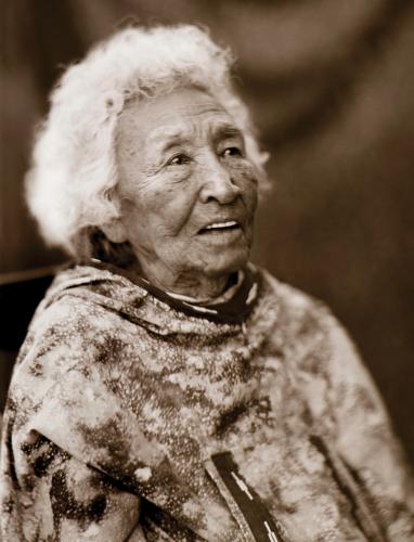 A sepia portrait of an elder with short white hair, looking into the distance