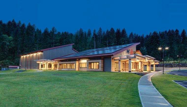A building with cedar pillars, illuminated at night