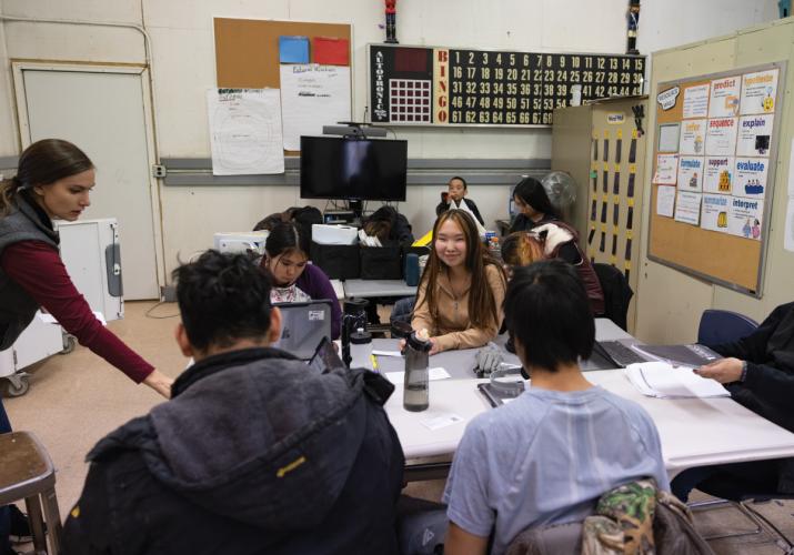 Group of students sitting at a table in a classroom.