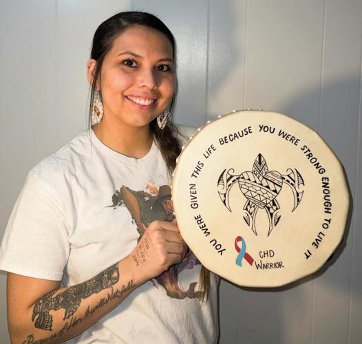 Nakiya Edwards holding a drum with a sea turtle design.