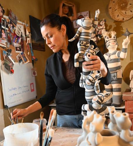 Kathleen Wall paints ceramic clown sculpture in art studio