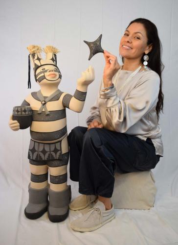 Kathleen Wall posing with clown sculpture on solid white background