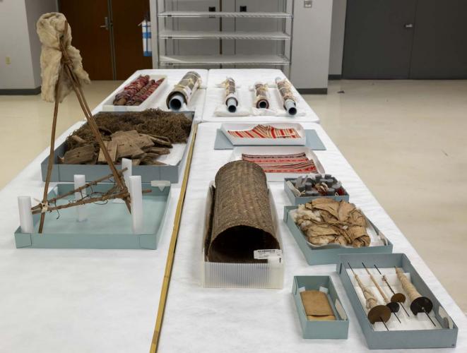 Historical textiles and weaving tools arranged on a tabletop.
