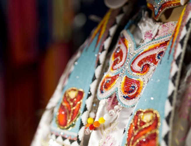 Intricate red, yellow, and teal beadwork depicts a butterfly and roses.