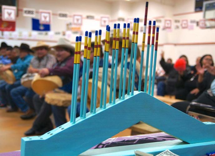 Decorated blue and yellow and blue and red sticks are stacked vertically on a triangular scoring tower.