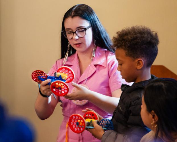 Person showing a robot to a child.