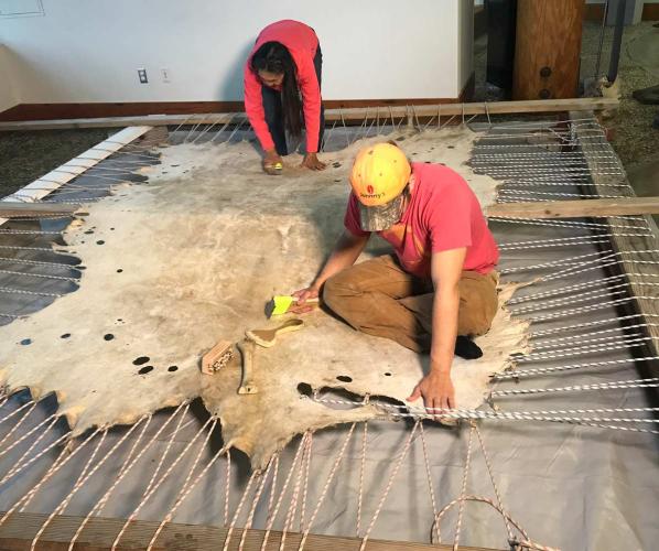 Helen Dick MacLean (Dena’ina) and Joel Isaak (Kenaitze) stretch out a moose hide