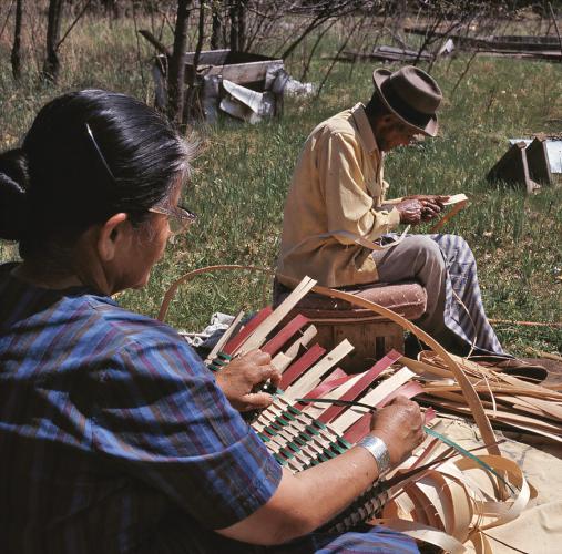 Lowe's parents sit and work on wooden baskets.