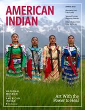 Cover of the Spring 2023 issue. 4 female jingle dress dancers stand side-by-side in a field.