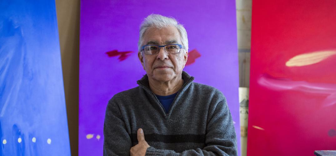 Portrait of Robert Houle in front of his paintings.