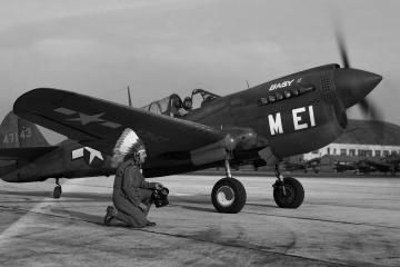 Horace kneels in front of a P-40 Warhawk at MacDill Field. Tampa, Fla., ca. 1944