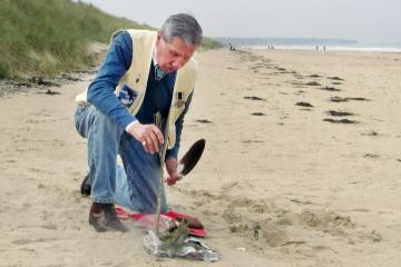 Charles Shay performing his sage ceremony on Omaha Beach