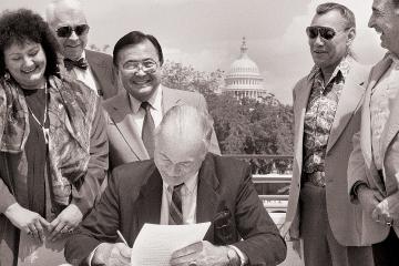 Susan Shown Harjo and others watch document signer