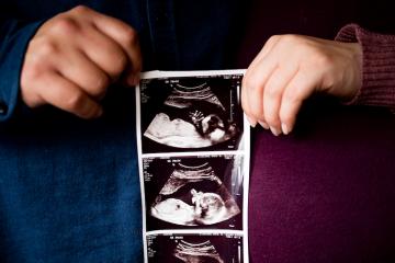 Michael Irvine and Leah Nelson holding sonegram of their unborn child