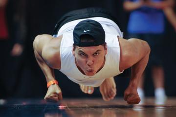 An athlete hops across the floor on his knuckles, moving like a seal