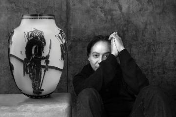 Artist Virgil Ortiz sits with one of his traditionally made Cochiti Pueblo pots depicting one of his "Recon Watchmen" characters.