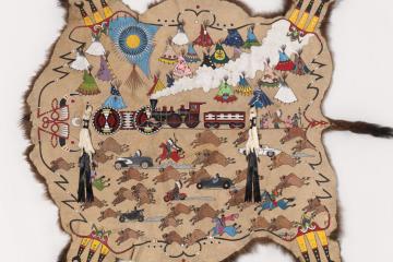 Bison hide painted with historic scenes, including a steam engine.