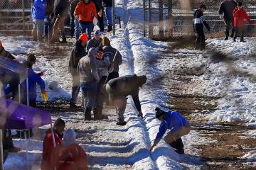 People on the Onondaga Nation dig a track dug out of snow.