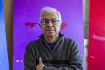 Portrait of Robert Houle in front of his paintings.