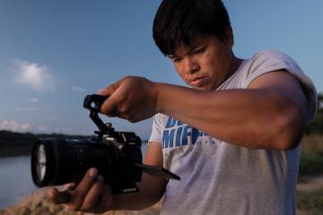 Peregrino Shanocua Chaeta holds a video camera 