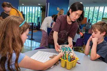 Sally Gunhee Kim shows a beaded hide to children at a program at NMAI