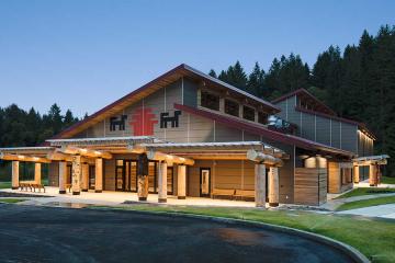 A building with cedar pillars, illuminated at night