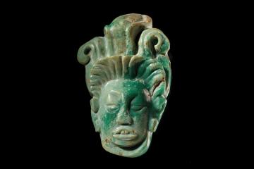 A carved greenstone pendant of the Mayan maize god Hun Hunahpu